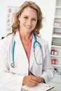 Mid age female doctor writing prescription Royalty Free Stock Photo