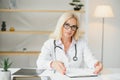 Mid age female doctor writing prescription Royalty Free Stock Photo