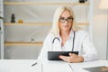 Mid age female doctor writing prescription Royalty Free Stock Photo