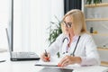 Mid age female doctor writing prescription Royalty Free Stock Photo