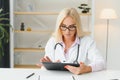 Mid age female doctor writing prescription Royalty Free Stock Photo