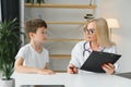 Mid age female doctor writing prescription Royalty Free Stock Photo