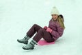 Mid age girl wearing winter hat sledding Royalty Free Stock Photo