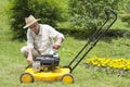 Mid age man repairing lawn mower Royalty Free Stock Photo