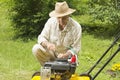 Mid age man repairing lawn mower Royalty Free Stock Photo