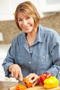 Mid age woman chopping vegetables Royalty Free Stock Photo