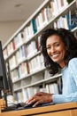 Mid age woman working on computer in library Royalty Free Stock Photo