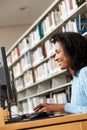 Mid age woman working on computer in library Royalty Free Stock Photo