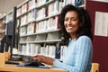 Mid age woman working on computer in library Royalty Free Stock Photo