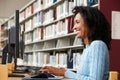 Mid age woman working on computer in library Royalty Free Stock Photo