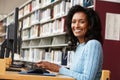 Mid age woman working on computer in library Royalty Free Stock Photo