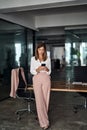 Mid aged business woman holding cellphone using phone in office, vertical. Royalty Free Stock Photo