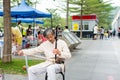 Mid-aged Chinese street musician playing Chinese traditional musical instrument-Erhu Chinese Violin in the Central Park of