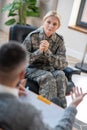 Mid-aged servicewoman listening to young psychoanalyst attentively