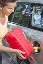 Mid aged woman adding fuel in car