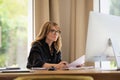 Mid aged woman sitting at desk and using computer for work Royalty Free Stock Photo