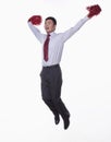 Mid- Air shot of businessman jumping and cheering with pompoms in hands, studio shot Royalty Free Stock Photo