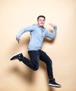 Mid-air shot of cheerful, successful, lucky teenager guy in casual outfit jumping with smile, hands up, triumphant, gesturing