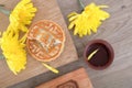 Mid-autumn moon cakes and a bowl of tea, golden chrysanthemums and wooden moon cake molds are scattered on the table.Chinese chara