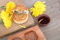 Mid-autumn moon cakes and a bowl of tea, golden chrysanthemums and wooden moon cake molds are scattered on the table.Chinese chara