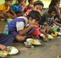 Mid day meal program, an Indian government initiative, is being running in a primary school. Pupils are taking their meal