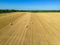 Mid level aspect view over a wheat field with bales of straw ready for collection Royalty Free Stock Photo