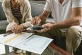 Active senior couple calculating domestic bills on sofa in living room at comfortable home Royalty Free Stock Photo