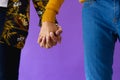 Mid section of biracial male couple holding hands on purple background Royalty Free Stock Photo