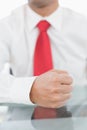 Mid section of a businessman with clenched fist on desk Royalty Free Stock Photo