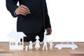 Mid section of businessman with paper cut out family, house and car at desk Royalty Free Stock Photo