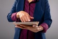 Mid section of businesswoman using digital tablet against grey background Royalty Free Stock Photo