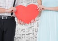 Mid section of couple holding a red heart