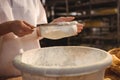 Mid-section of female baker sifting flour through a sieve Royalty Free Stock Photo