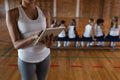 Mid section female basketball coach using digital tablet at basketball court