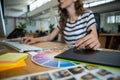 Mid section of female graphic designer using graphics tablet at desk Royalty Free Stock Photo