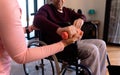 Mid section of female physiotherapist helping caucasian senior man to do exercise with dumbbells