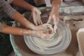 Mid section of female potter assisting girls