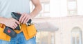 Mid-section of handy man with tool belt and drill Royalty Free Stock Photo