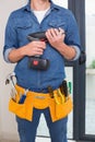 Mid section of a handyman with drill and toolbelt Royalty Free Stock Photo