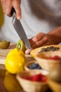 Mid-section of male staff cutting kiwifruit at organic section Royalty Free Stock Photo