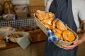 Mid section of male staff holding wicker basket of various breads at counter Royalty Free Stock Photo