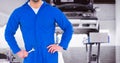 Mid section of mechanic standing with hands on hip holding wrench Royalty Free Stock Photo