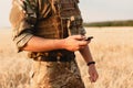 Mid section of military soldier using mobile phone