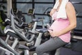 Mid section of pregnant woman on exercise bike