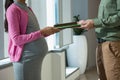 Mid section of pregnant woman giving file to colleague