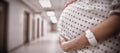 Mid section of pregnant woman standing in corridor Royalty Free Stock Photo