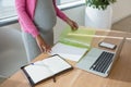 Mid section of pregnant woman working at desk