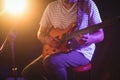 Mid section of singer playing guitar in nightclub Royalty Free Stock Photo