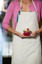 Mid-section of staff holding jar of maraschino cherry Royalty Free Stock Photo