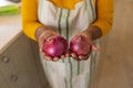 Mid section view of senior african american woman holding onions in kitchen